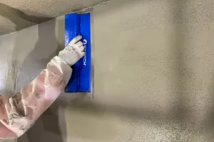The coating is smoothed with a spatula.